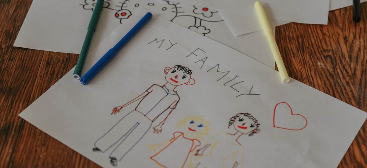 A hand-drawn family portrait using colored markers on paper, showcasing creativity and love.