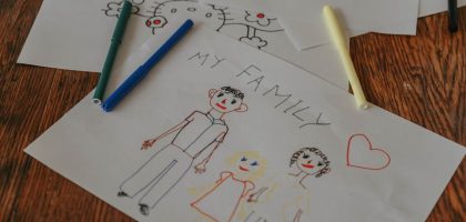 A hand-drawn family portrait using colored markers on paper, showcasing creativity and love.